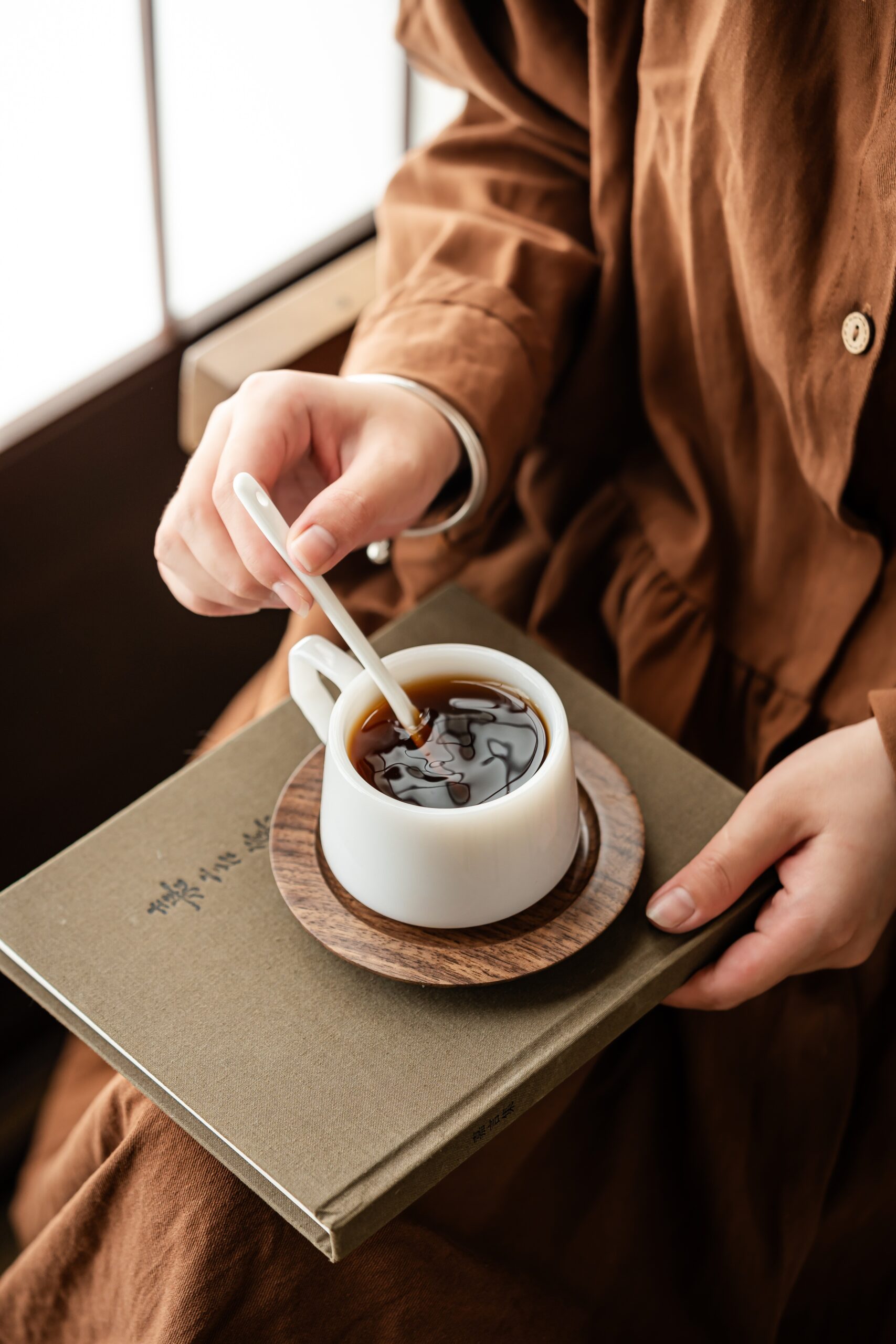 Kvinna som rör i en kopp kaffe